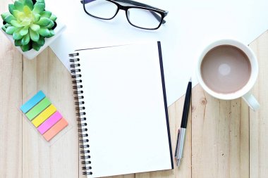 Natürmort, iş, büro malzemeleri, planlama veya eğitim kavramı: Top görünümü veya açık defter ile boş sayfalar ve kopya alanı eklemek için hazır ofis masada kahve fincanı yatıyordu veya sahte kadar düz