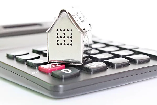 Business, finance, saving money, property ladder or mortgage loan concept : House model and calculator on office desk table