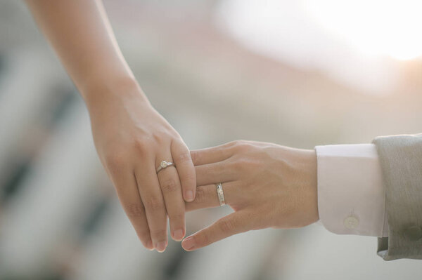 close up bride groom holding hand with sunset (selective focus)