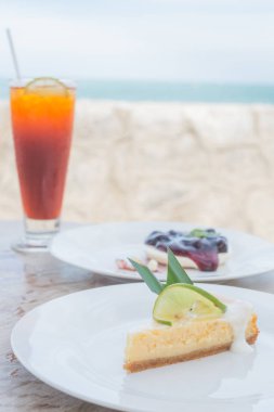 Peynirli kek, krepteki ve limonlu çay önünde limonlu peynir kek