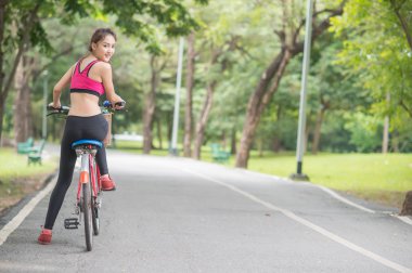 genç çekici kadın içme suyu parkta plastik şişe