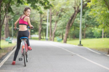 genç çekici kadın içme suyu parkta plastik şişe