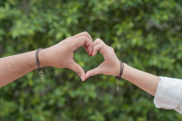 Händer i form av kärlek hjärta på natur bakgrund — Stockfoto