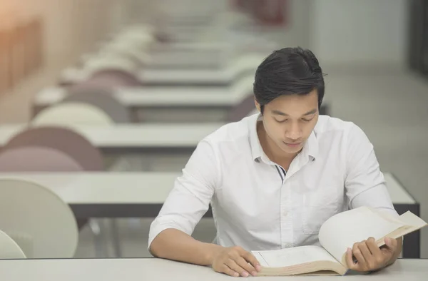 Schüler lesen Buch im Bibliotheksunterricht für die Prüfung — Stockfoto