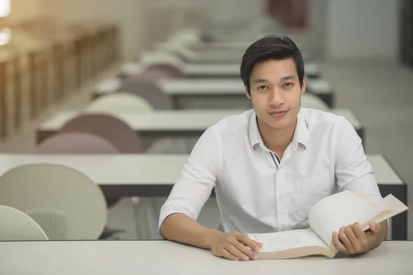 Schüler lesen Buch im Bibliotheksunterricht für die Prüfung — Stockfoto