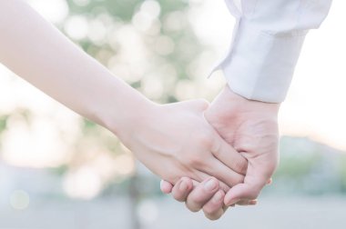 Onların el ele tutuşarak sevimli genç yeni evliler ve yakın çekim 