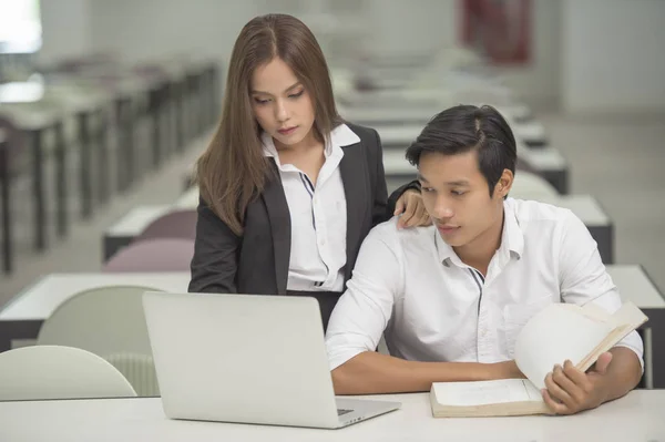 Business people looking at laptop