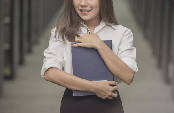 Wanita bisnis muda yang bahagia dengan buku teks di gedung kantor — Stok Foto