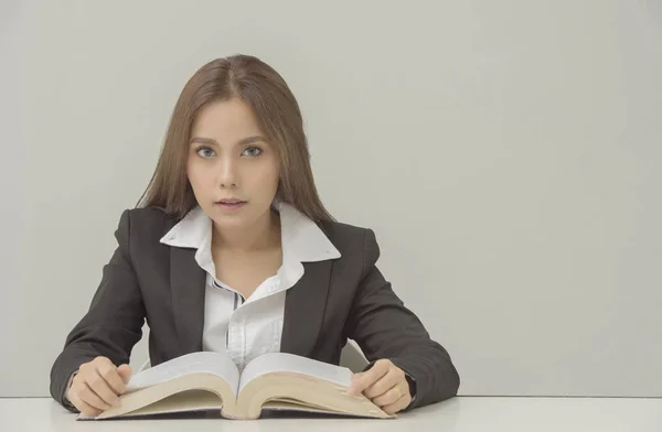 Retrato de estudiante feliz o mujeres ocupadas sentadas y antes de libro de texto y mirando a la cámara —  Fotos de Stock