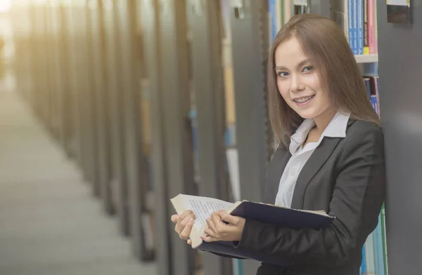 Gelukkig jonge zakenvrouw met een leerboek op kantoorgebouw — Stockfoto