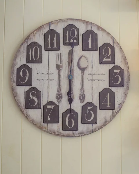 Um relógio de parede no fundo papel de parede de madeira — Fotografia de Stock