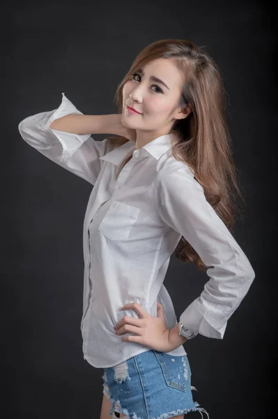 Portrait of model beautiful girls wearing White shirt and short jeans in clean skin beautiful and smart concept with Black  fabric background — Stok Foto