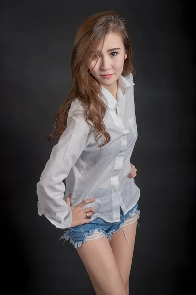 Portrait of model beautiful girls wearing White shirt and short jeans in clean skin beautiful and smart concept with Black  fabric background — Stok Foto