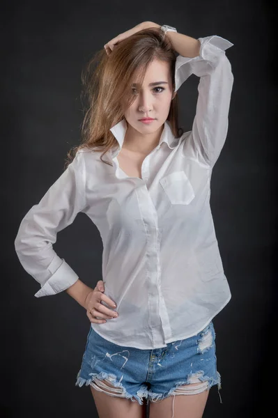 Portret van model mooie meisjes dragen witte shirt en korte spijkerbroek in schone huid mooi en slim concept met zwarte stof achtergrond — Stockfoto