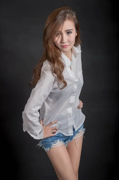 Porträtt av modell vackra flickor som bär vit skjorta och korta jeans i ren hud vacker och smart koncept med svart — Stockfoto