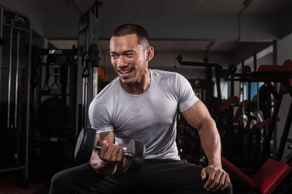 Onun vücut dumbbell Modern bir fitness merkezi ile eğitim kas Oluşturucu adam