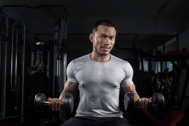Onun vücut dumbbell Modern bir fitness merkezi ile eğitim kas Oluşturucu adam
