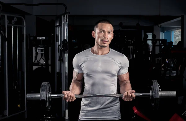 モダンなフィットネス センターでバーベルで彼の体をトレーニング筋肉ビルダー男 — ストック写真