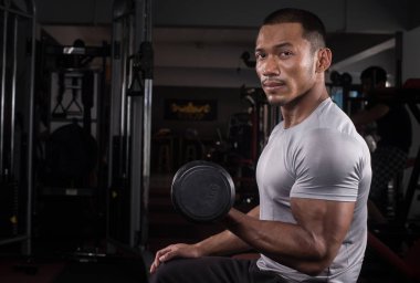 Onun vücut dumbbell Modern bir fitness merkezi ile eğitim kas Oluşturucu adam