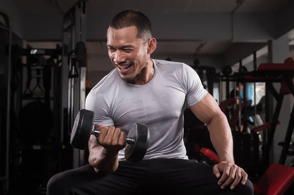 Onun vücut dumbbell Modern bir fitness merkezi ile eğitim kas Oluşturucu adam
