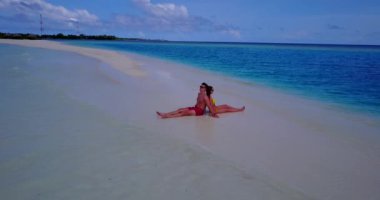 Genç bir adam ve kadın deniz kıyısında güneşleniyorlardı. Tropik bir tatil köyünde dinlenen güzel bir çift.   