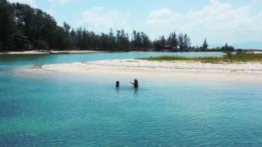 İki güzel kız sahilde suda oynuyorlar.  