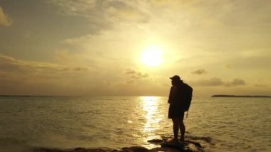 Gün batımında Sahilde Yürüyen Kadın