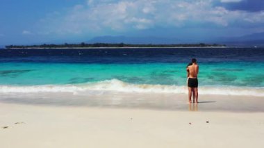 Birbirlerine aşık çiftler güzel bir okyanusun kıyısında duruyorlar, tropikal adada dinleniyorlar, turizm konsepti. 