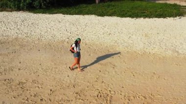 Sırt çantalı kadın turist tropik ada sahillerinde yürüyor, yaz tatili konsepti  