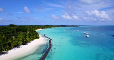 Kıyı şeridini savunan dalgalar, mavi denizde sürüklenen beyaz yatlar. Tayland, Asya gezisi.