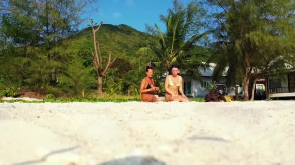 Dwie Młode Dziewczyny Siedzą Piaszczystym Wybrzeżu Rozmawiają Piękne Kobiety Odpoczywające — Wideo stockowe