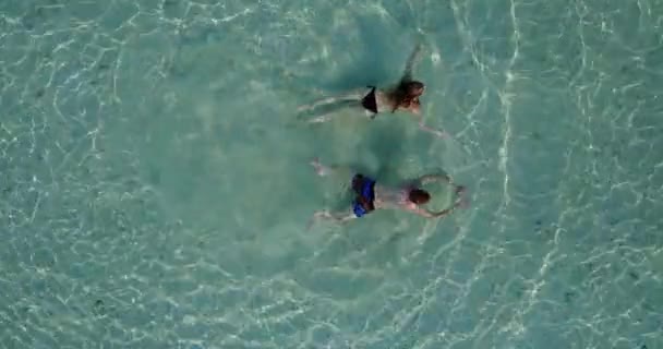 在绿松石海中游泳的年轻夫妇 — 图库视频影像