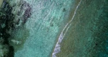 Beyaz kumlu sahilde uçan turkuaz dalgaların insansız hava aracı görüntüsü. Maldivler 'de yaz tatili.