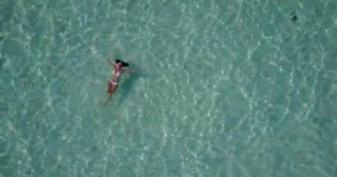 Maldivler 'de deniz kenarında beyaz bikinili genç bir kadın..