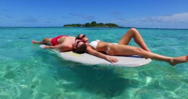 Harika bir çift sörf tahtası üzerinde birlikte sörf yapıyorlar Maldivler 'de okyanus denizinde.