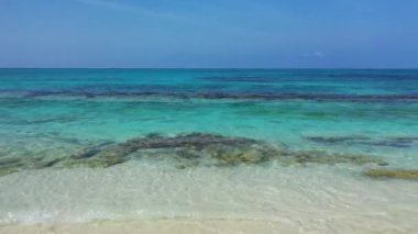 Turkuaz okyanus suyunun ve sahil şeridindeki beyaz kumun yakın görüntüsü. Bora Bora Adası 'na yaz gezisi, Fransız Polinezyası.