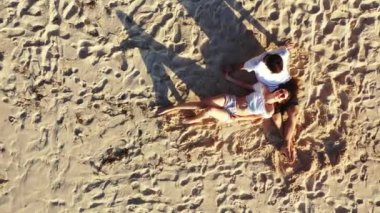 Bir adamın sevgilisiyle kumlu ada sahillerinde, romantizm ve yaz seyahati konseptinde rahatlarken çekilmiş bir video. 