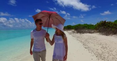 Mutlu genç çift güneşli bir günde kumsalda birlikte eğleniyor.