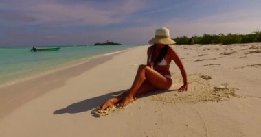 Genç bir bayan tropik sahilde güneşli bir günün tadını çıkarıyor. Maldivler plajında mutlu genç bir kadın.