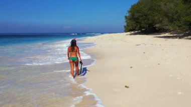 Yaz plajında elinde palet aletleri olan bir kadın. 