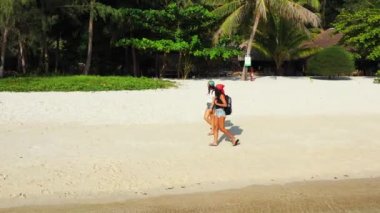 Sahilde yürüyen iki bayan arkadaşın görüntüsü. 