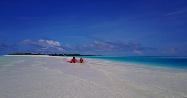 若い男と女は海の海岸と日光浴に横たわっていた 美しいカップルは熱帯リゾートに休みます — ストック動画