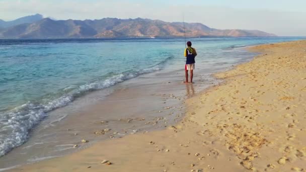 バリの島の漁師は海のビーチでロッドで釣り — ストック動画
