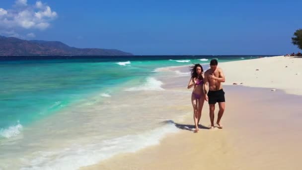 幸せな若いです女性歩くと彼女のボーイフレンドで熱帯の島の海岸線 夏の旅行のコンセプト — ストック動画