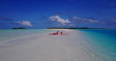 Genç çift dinleniyor ve Maldivler 'deki tropikal adanın okyanus kıyısında tatilin tadını çıkarıyor..