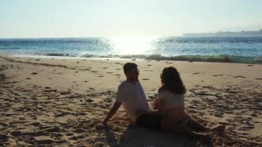Romantik çift tropik sahilde oturuyor.