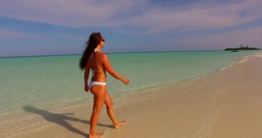 Kumsalda beyaz bikinili mutlu bir kadın. Tatil, güzel deniz ve doğal yaşam..