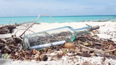 Plajdaki cam şişenin yakın görüntüsü. Bora Bora 'nın egzotik doğası, Fransız Polinezyası. 