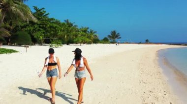 Sahilde yürüyen kadınların yüksek açılı görüntüleri. 