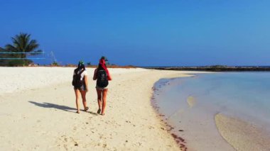 Sahilde yürüyen kadınların yüksek açılı görüntüleri. 